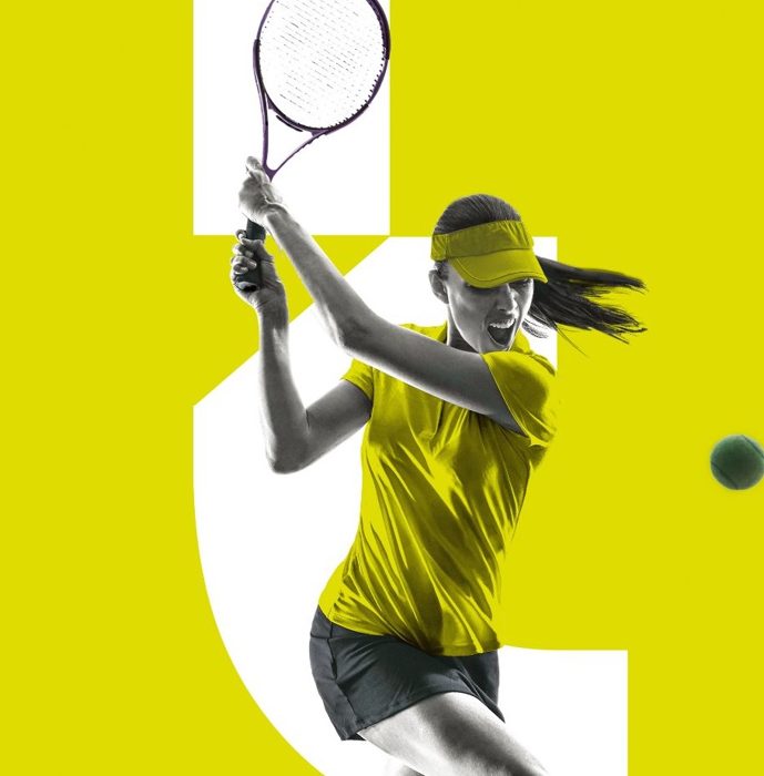 A tennis player mid-swing on a chartreuse court
