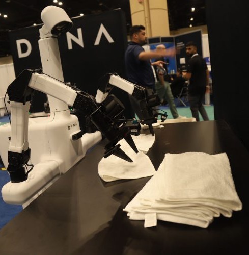 Dyna arm folding white towels at a trade show