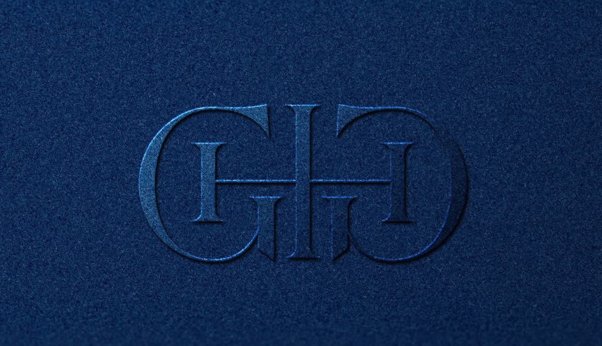 Embossed heraldic monogram on navy felt